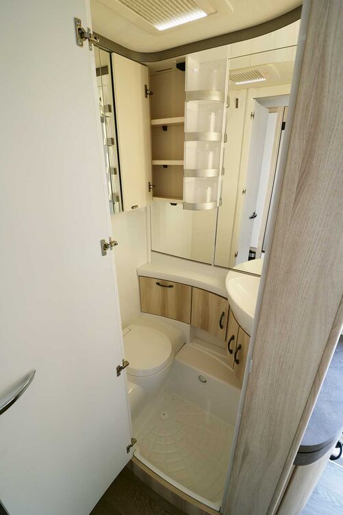 Der helle Waschraum mit der formschönen Banktoilette wird durch die zahlreichen Spiegelflächen optimal in Szene gesetzt.