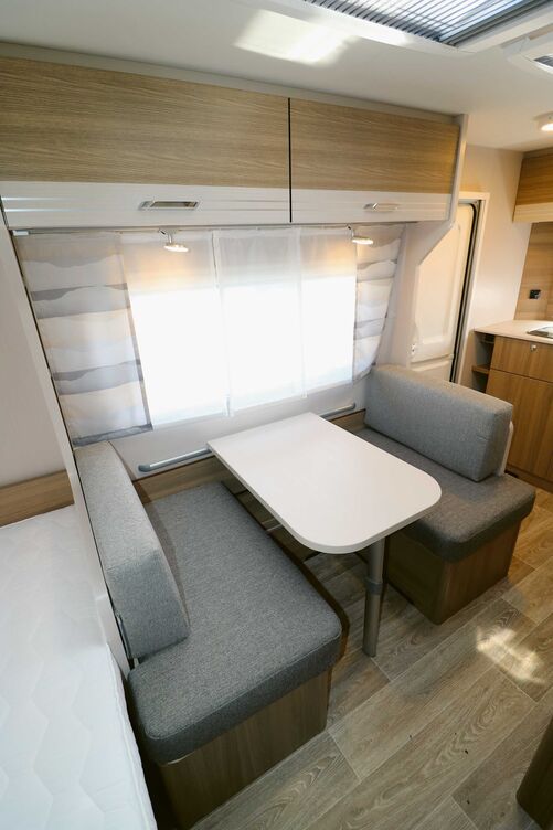 Das Interieur mit den warmen Holzfarben vermittelt zusammen mit der Bodenoptik und den Gardinen- und Polsterdesigns eine ansprechende Wohnatmosphäre.
