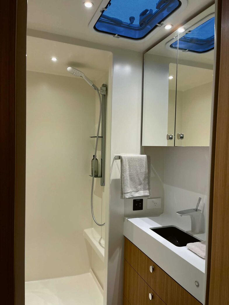 Blick ins Badezimmer in Wohnwagenmitte des Romotow mit Lavabo und separater Dusche.