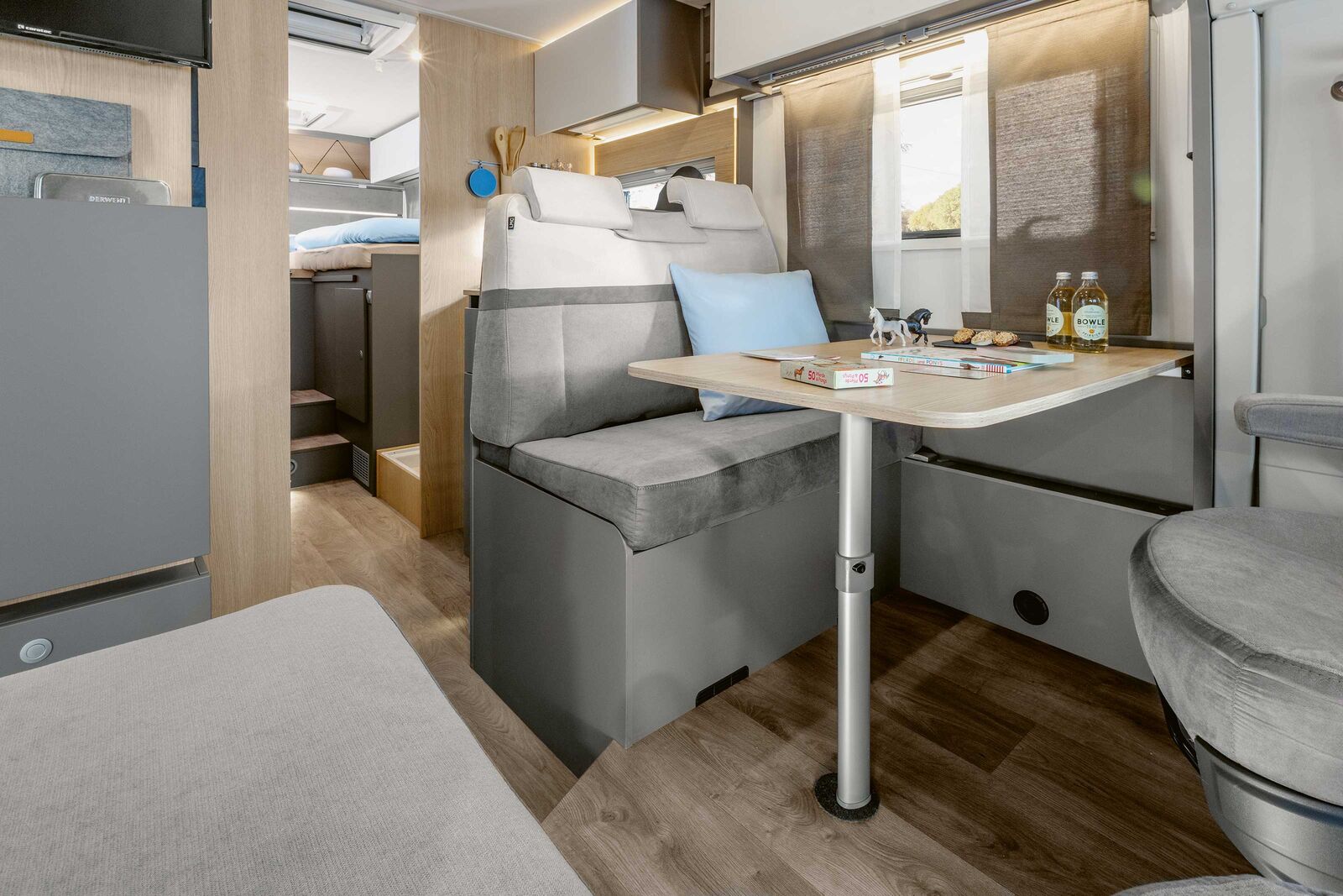 Ausgestattet mit einem gradlinigen und schlichten Design in hellem Eichenholz und Akzenten in mattem Weiss und Taupe bietet das Mehrgenerationenfahrzeug bis zu 6 Schlafmöglichkeiten.